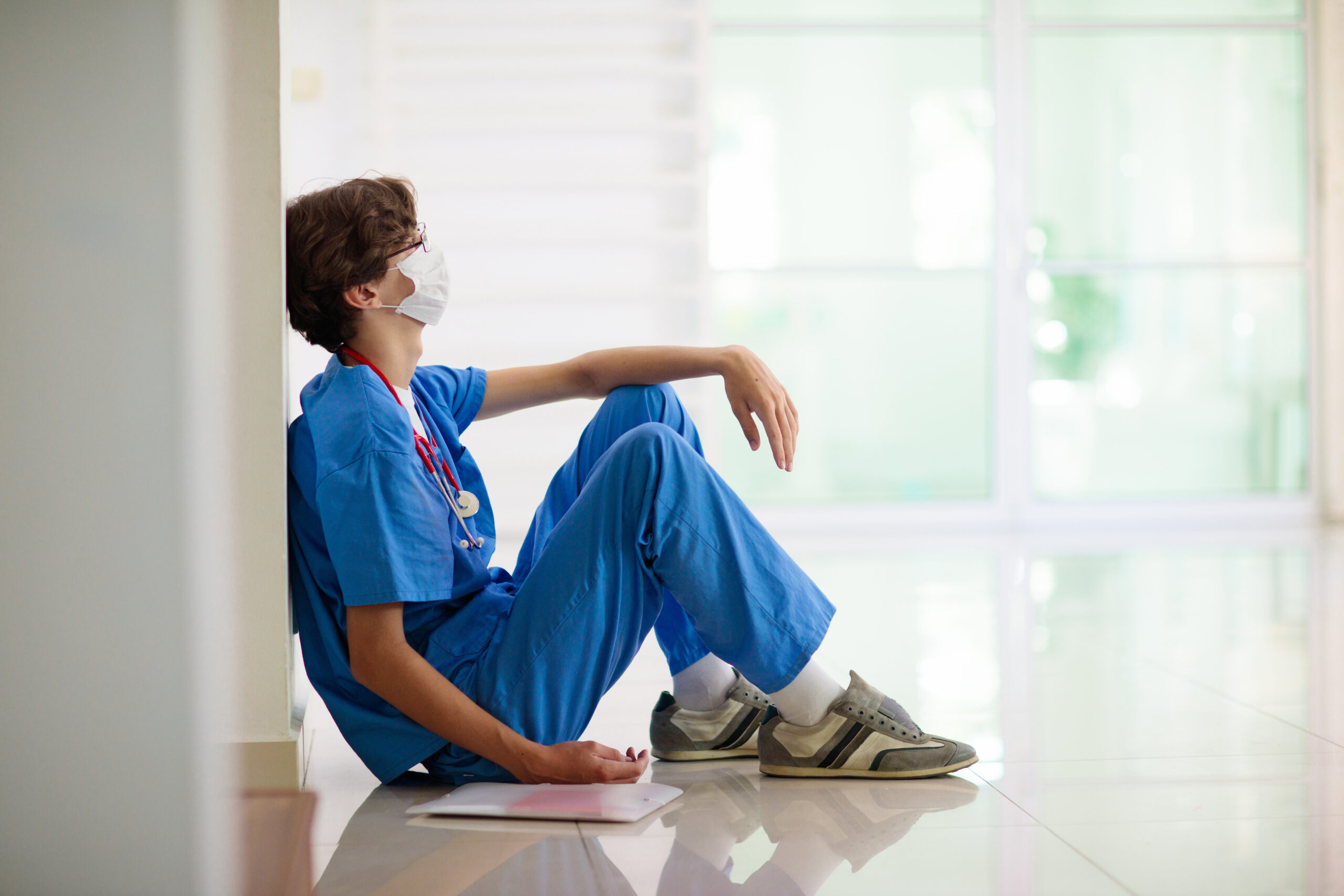 nurse in blue sitting on the floor